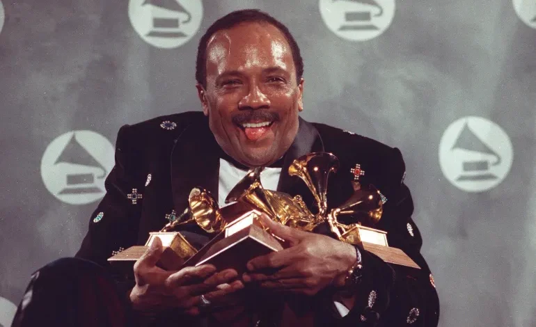 Quincy Jones cradles his Grammy awards, including the album of the year award, for his eclectic album Back on the Block during the 33rd annual Grammy Awards, at New York's Radio City Music Hall night of February 20, 1991