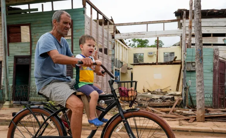 Residents cycle past homes damaged when Hurricane Rafael passed through Batabano, Cuba, on November 7