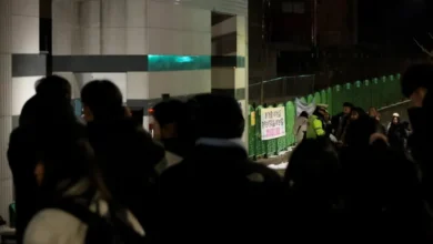 People gather outside an elementary school building in Daejeon where a teacher stabbed an student to death on February 10, 2025